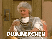 a woman is sitting in a chair with the word dummerchen written above her