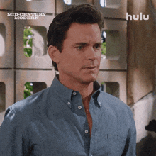 a man in a blue shirt is standing in front of a wall with the words mid century modern written on it