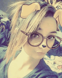 a girl wearing glasses has a cartoon lion 's head on her head