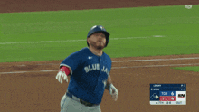 a baseball player wearing a blue jays jersey is running towards home plate