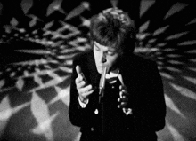 a man is smoking a cigarette in front of a microphone .