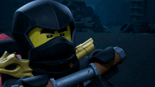 a lego ninja is holding a sword in his hand