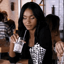 a woman is drinking a drink through a straw in a restaurant .