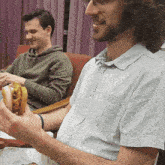a man is holding a fried chicken sandwich in his hand