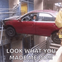 a red car is stuck in a building and says look what you made me do