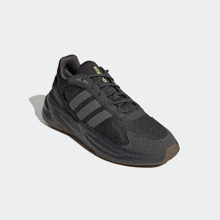 a pair of black adidas shoes with a brown sole