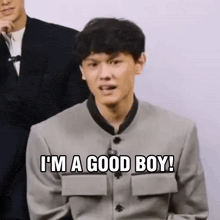 a man in a suit is making a funny face and says `` i 'm a good boy '' .