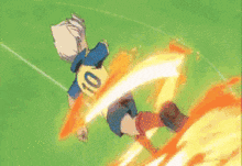a cartoon character is kicking a ball on a soccer field while surrounded by flames .