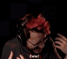 a man with red hair and glasses is wearing headphones and says eww .