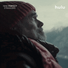 a poster for nine perfect strangers shows a man in a red beanie