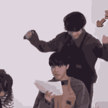 a group of people are standing around a table holding papers .
