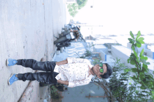 a boy wearing sunglasses is standing on a sidewalk with a motorcycle in the background