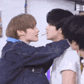 a couple of boys are standing next to each other and one of them is eating a candy bar .