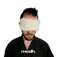 a man with a blindfold on his eyes with the word mcdh below him