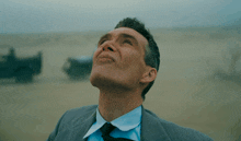 a man in a suit and tie looks up in the sky