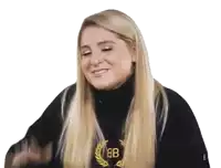 a woman with long blonde hair is wearing a black turtleneck sweater with a laurel wreath on it .