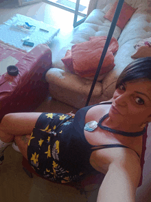 a woman in a black tank top is laying on a chair in front of a couch