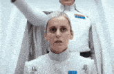 a woman in a white uniform has a badge on her chest that says ' emperor '