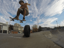 a skateboarder is doing a trick with a tire in the background