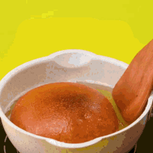 a wooden spoon is being used to stir food in a pot