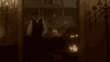 a man in a suit stands in front of a window with candles