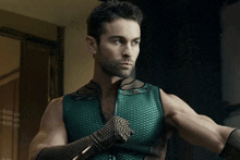 a man in a green superhero costume is standing in a dark room .