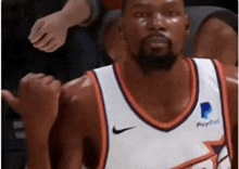 a basketball player wearing a paypal jersey is giving a thumbs up