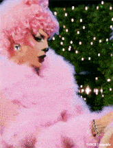 a drag queen is wearing a pink fur stole