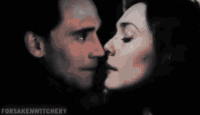 a man and a woman are kissing in the dark .