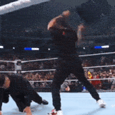 a man in a black shirt is kicking another man in the face