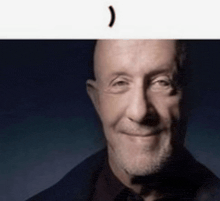 a close up of a man 's face with a beard smiling .