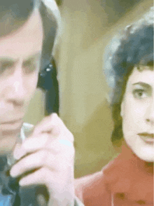 a man and woman are talking on a telephone