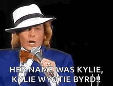 a man singing into a microphone with the words her name was kylie kylie wyotie byrd .