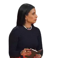 a woman in a black top and pearls is holding a notebook