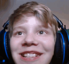 a close up of a person wearing headphones with a smile on their face