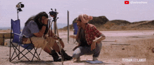 a man taking a picture of another man with a tripod in the desert with the words terbaik kali langit at the bottom