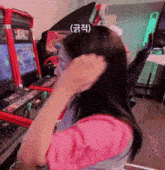 a woman is sitting in front of a video game machine in an amusement park .