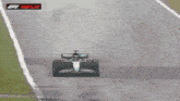 a race car is driving down a wet track with the words f1 replay on the bottom right