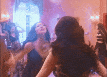 a group of women are dancing in front of a mirror in a room