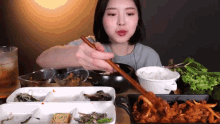 a woman is eating food with chopsticks in a restaurant