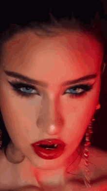 a close up of a woman 's face with red lips and blue eyes