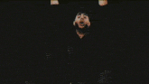 a group of people are standing in a dark room with their hands up