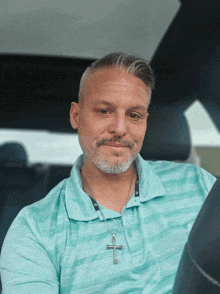 a man with a beard wearing a cross necklace