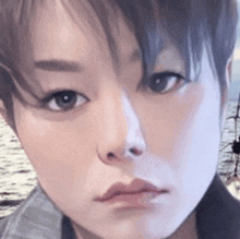 a close up of a woman 's face with a boat in the background