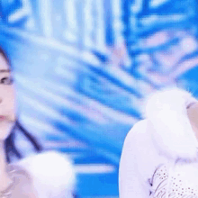 a woman in a white dress is standing in front of a blue wall .