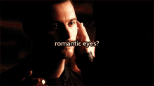 a close up of a man 's face with the words " romantic eyes " above him