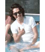 a man wearing sunglasses is giving a thumbs up