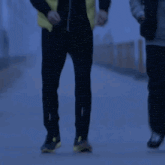 a man in a yellow vest stands next to a sign that reads 2132km