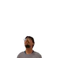 a man with glasses looks up at a green cross on his head