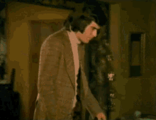 a man in a suit holds a woman 's hand